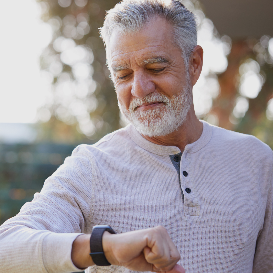 A man checks his wearable pulse oximeter watch to measure his heart rate and blood oxygen levels