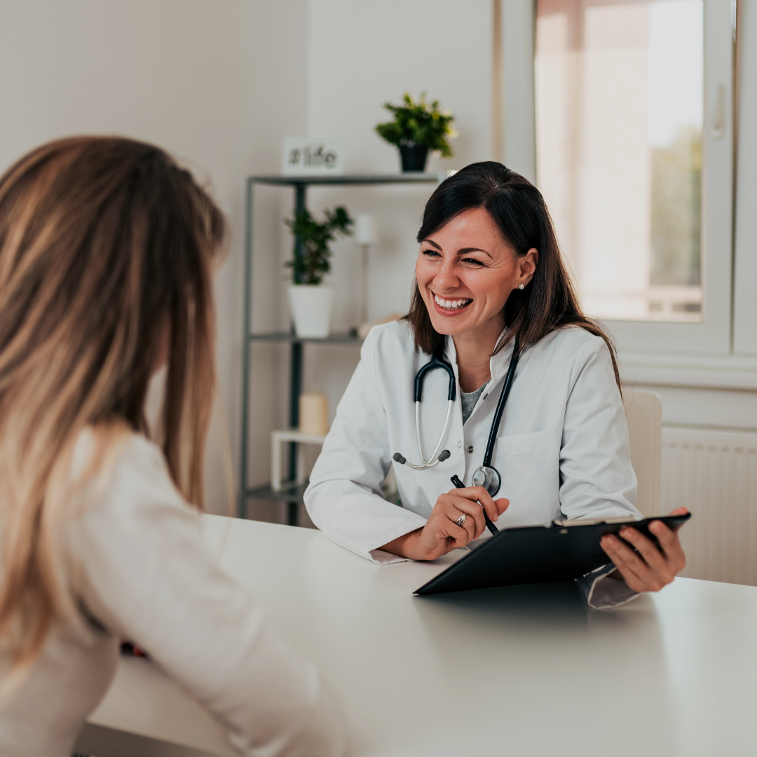 A doctor smiles at her patient in her office