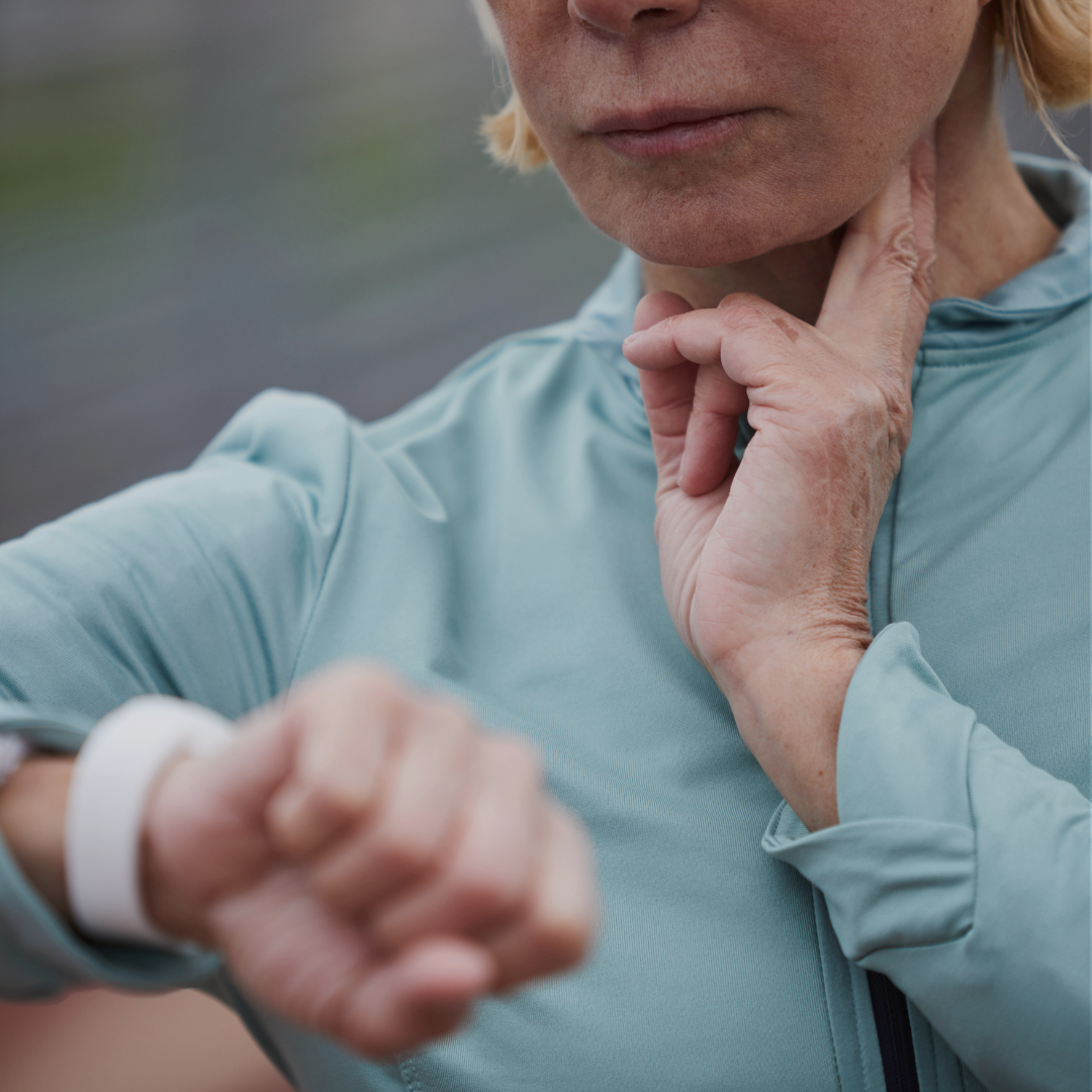 A woman stops her workout to measure and monitor her heart rate